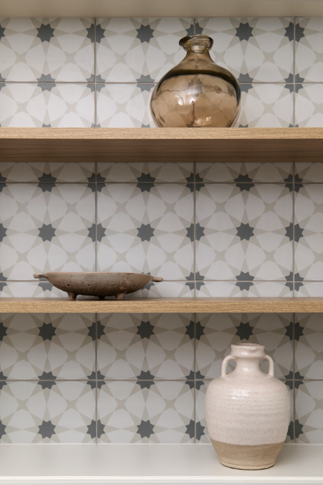 open wooden shelving in kitchen with mosaic backsplash